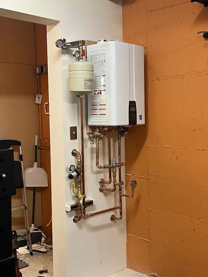 Plumbing technician inspecting water heater connections in Difficult Run